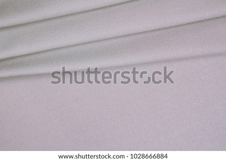 Gray woolen crumpled wrinkled fabric with waves, background crumpled tissue
