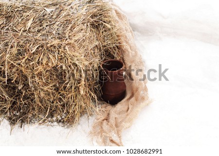 Background image in a rustic style. Still life with a jug, a coarse cloth and a bale of hay. Can be used as a background or ad decoration wich copy space.