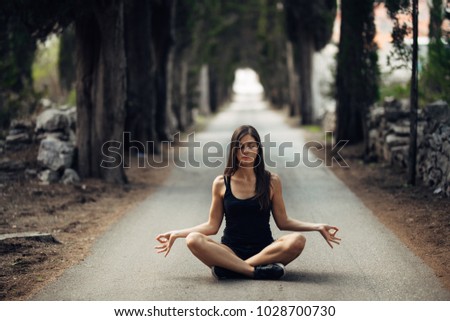 Carefree calm woman meditating in nature.Finding inner peace.Yoga practice.Spiritual healing lifestyle.Enjoying peace,anti-stress therapy,mindfulness meditation.Positive energy.Controling mind