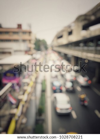 Blurred image of many car on the road at the rush hour in Bangkok with sky walk for faster than use car, used fuel make the pollution to global warming. transportation concept. vintage tone.