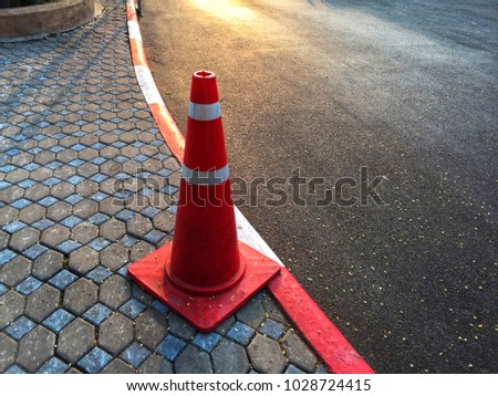 Traffic cone is placed on the street footpath. Traffic background.