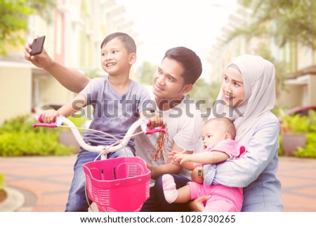 Happy muslim family taking selfie spending quality time in summer