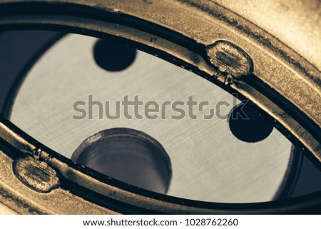 Unusual robotic eye in steampunk style. Empty robot look. Background pattern close-up.