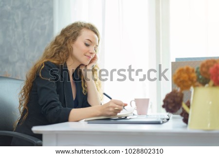 Business woman looking at laptop computer in office.Business woman working at office with laptop and documents on her desk.Start up project.