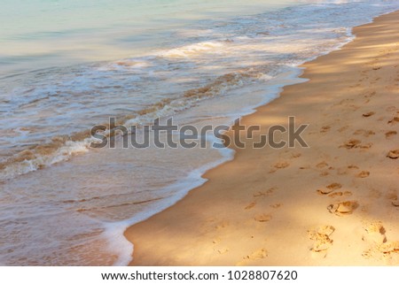 Tropical beach holiday concept - Close-up of waves and footprints on tropical sandy beach, Layan Beach, Phuket, Thailand, 