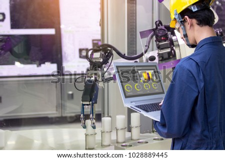 Industry 4.0 Robot concept .Engineers use laptop computers for machine maintenance, automation tools, robot arm at the factory.
