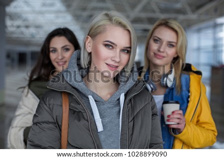 Portrait of smiling lady looking at camera. Focus on her. Friends on background