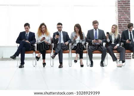 employees with smartphones sitting in the lobby