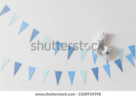 Blue color flags garland with balloon in shape of number 4 on white wall. Party banner. 