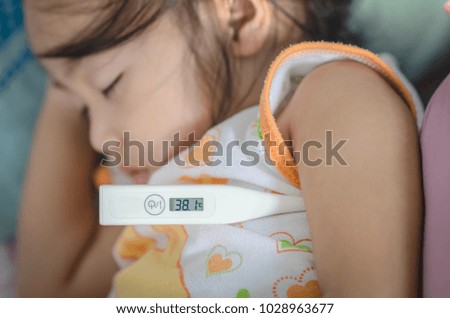 Close-up thermometer.measuring temperature of kid. Sick child with high fever laying and holding thermometer. checks the temperature of baby. Close-up thermometor on baby sick background.
