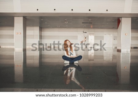 The girl waits for an airport plane with a camera