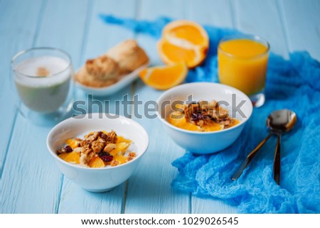 Greek Yogurt in a Bowl with Spoons Coffee and Orange Fresh on Wooden Blue Background                       