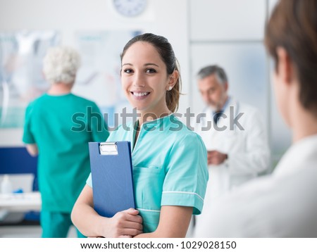 Young female medical student working at the hospital and medical staff, she is holding medical records Royalty-Free Stock Photo #1029028150