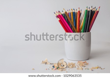 Crayons in a vase on a white background.