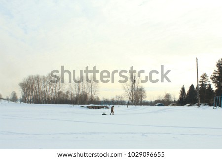 The fisherman walks along the frozen pond home. Winter fishing. Landscape.