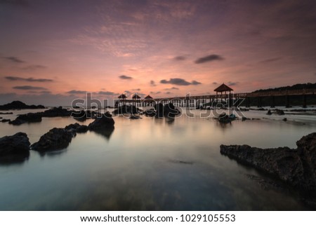 A Long exposure picture of golden sunrise with stone jetty