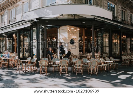 Typical view of the Parisian street with tables of brasserie (cafe) in Paris, France. Architecture and landmarks of Paris. Postcard of Paris Royalty-Free Stock Photo #1029106939