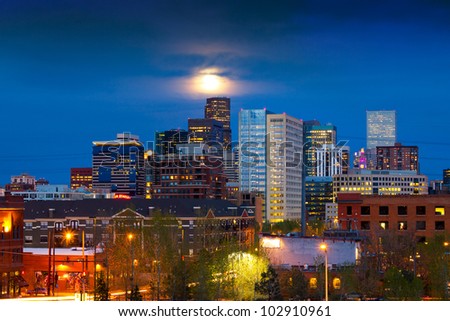 Denver skyline at dusk with the full moon rising above