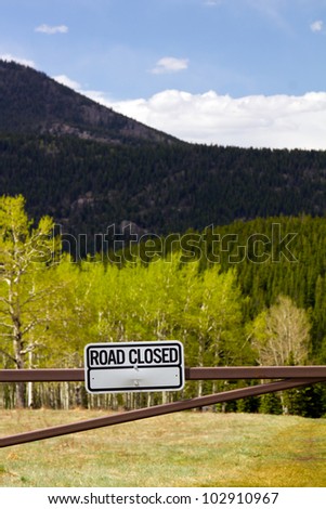 Road closed sign to a dirt road in the outdoors