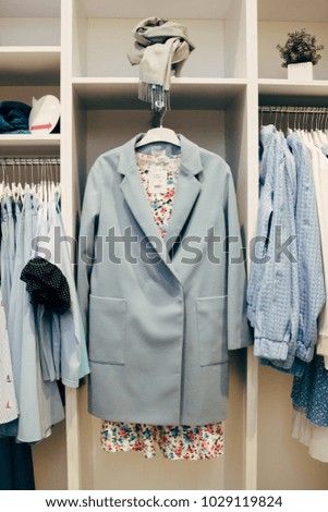 A row of clothes hanging on a rack in pastel colors