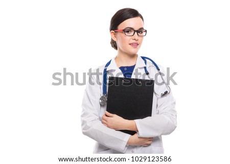 Young woman doctor with stethoscope holding clipboard with her hands in white uniform on white background