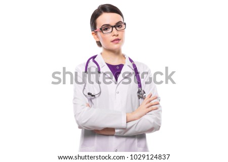 Young female doctor with crossed arms with stethoscope in white uniform on white background