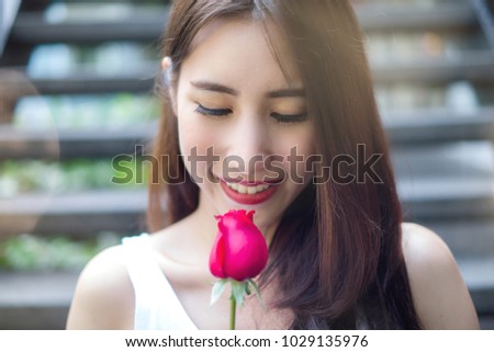 Beautiful Asian girl holding red rose with happiness smile in her wonderful Valentine's Day