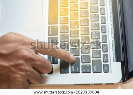 Hand pressing enter button on keybord or computer.