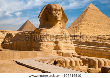 Beautiful profile of the Great Sphinx including pyramids of Menkaure and Khafre in the background on a clear sunny, blue sky day in Giza, Cairo, Egypt Royalty-Free Stock Photo #102914510