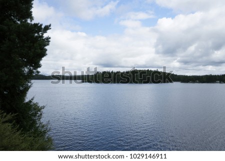 Picture of a lake in taken mid day with an island at a distance