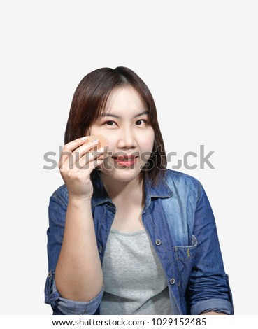 Asian short hair woman doing makeup by using puff to put powder on her face. picture on isolated white background.