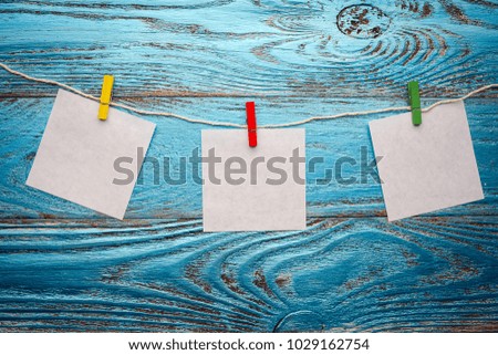 Three hanging paper on wooden background