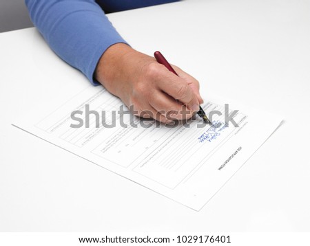 a female hand filling in a job application form with pen