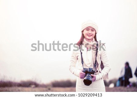 Beautiful smiling young woman happy and enjoying fog on the beautiful fog mountain with vacation in hands holding camera walk around looking some locations for shooting, on blurred background, travel 