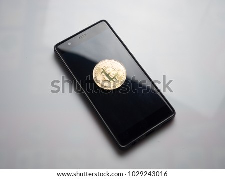 golden bitcoin on mobile phone