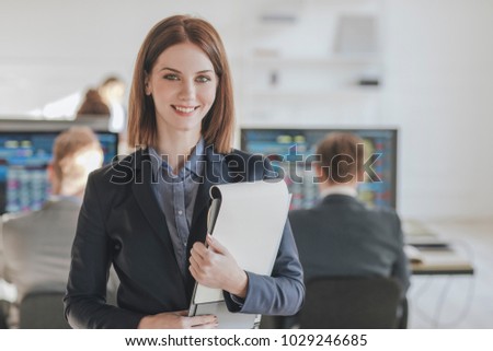Beautiful smiling Caucasian woman standing at office and looking at camera.