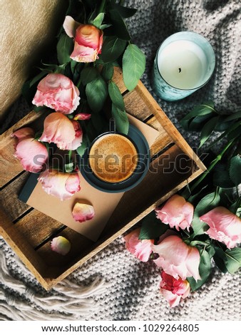 Morning coffee on wooden tray with roses and candle. Hygge style photo. 