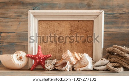 Vintage picture frame with sea shells on wood table top background
