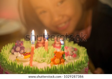 Happy Kid birthday Party with birthday delicious cake.Asian child smile and blowing out candle.Happy birthday concept

