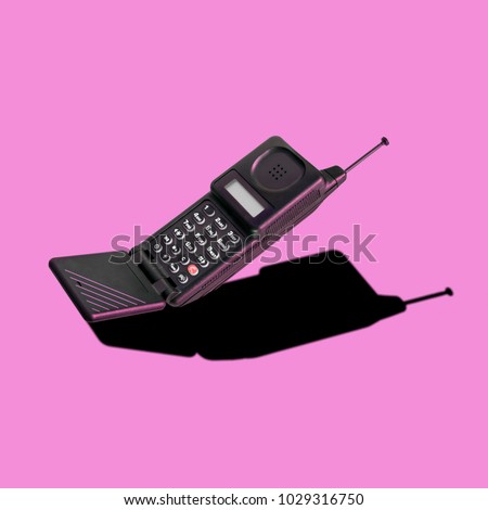 Old classic analog mobile phone nostalgia in punchy color, with aerial and microphone flip, for creative design cover, CD, poster, book, printing, gift card, flyer, magazine web & print Royalty-Free Stock Photo #1029316750
