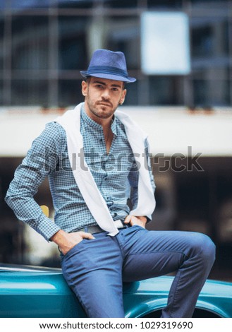 Fashion man standing near retro cabriolet car outdoors