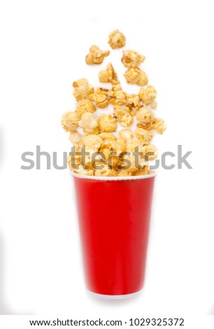 Popcorn in red tall bucket isolated on white background.