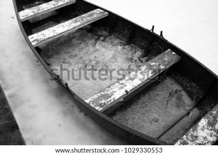 Boat decor on the ice rink. Frozen water image. Snowy weather and snowflakes on the boat.