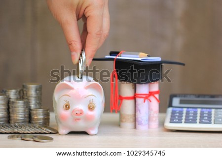 Woman hand putting coins money into piggy with graduates hat on banknote on wood background, Saving money for education concept