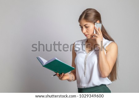 Beautiful business woman talking on the phone on a white background