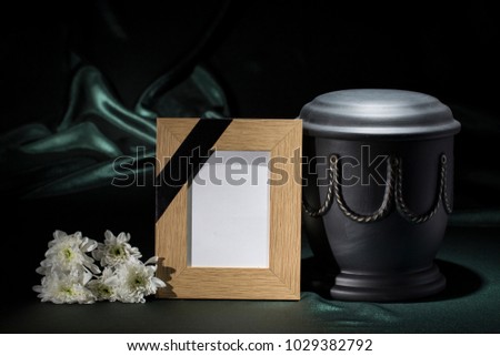 black cemetery urn with natural wooden frame for sympathy card
