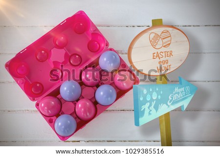 Easter egg hunt sign against multicolored easter eggs in carton
