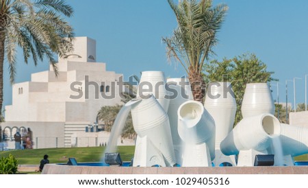 View of Corniche in Doha with the water pots fountain landmark timelapse, with the distant business towers skyline. Islamic museum is in the background.