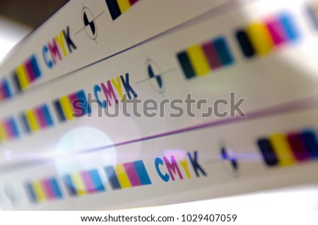 CMYK test printed on white paper with lights effect. Cyan, magenta, yellow, black and registration mark.