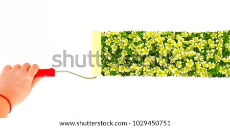 Person painting flowers on a white wall with a roller brush